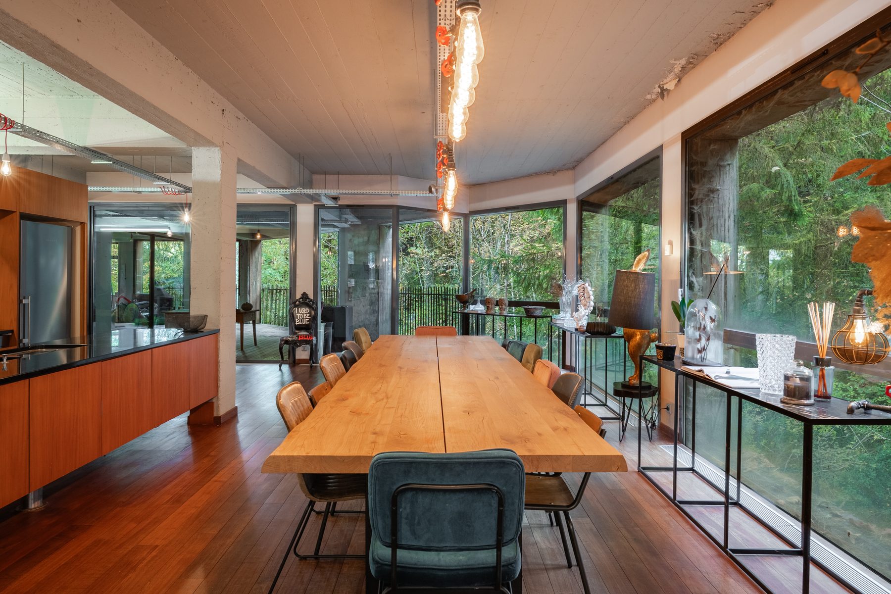 Grande table de salle à manger en bois massif face aux baies vitrées