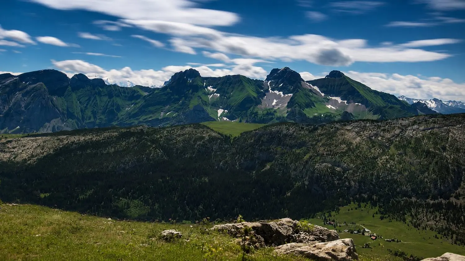 Panorama du massif des Bornes en été, ciel et alpages