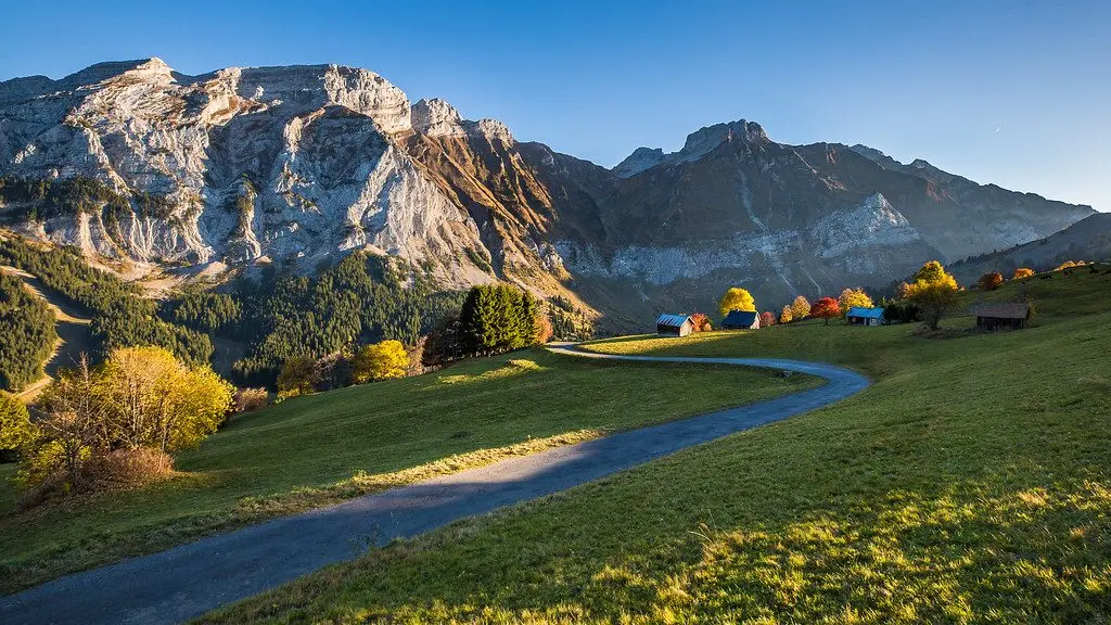 Alpages dorés et chalets dispersés sur les hauteurs à l'automne, falaises du Bargy