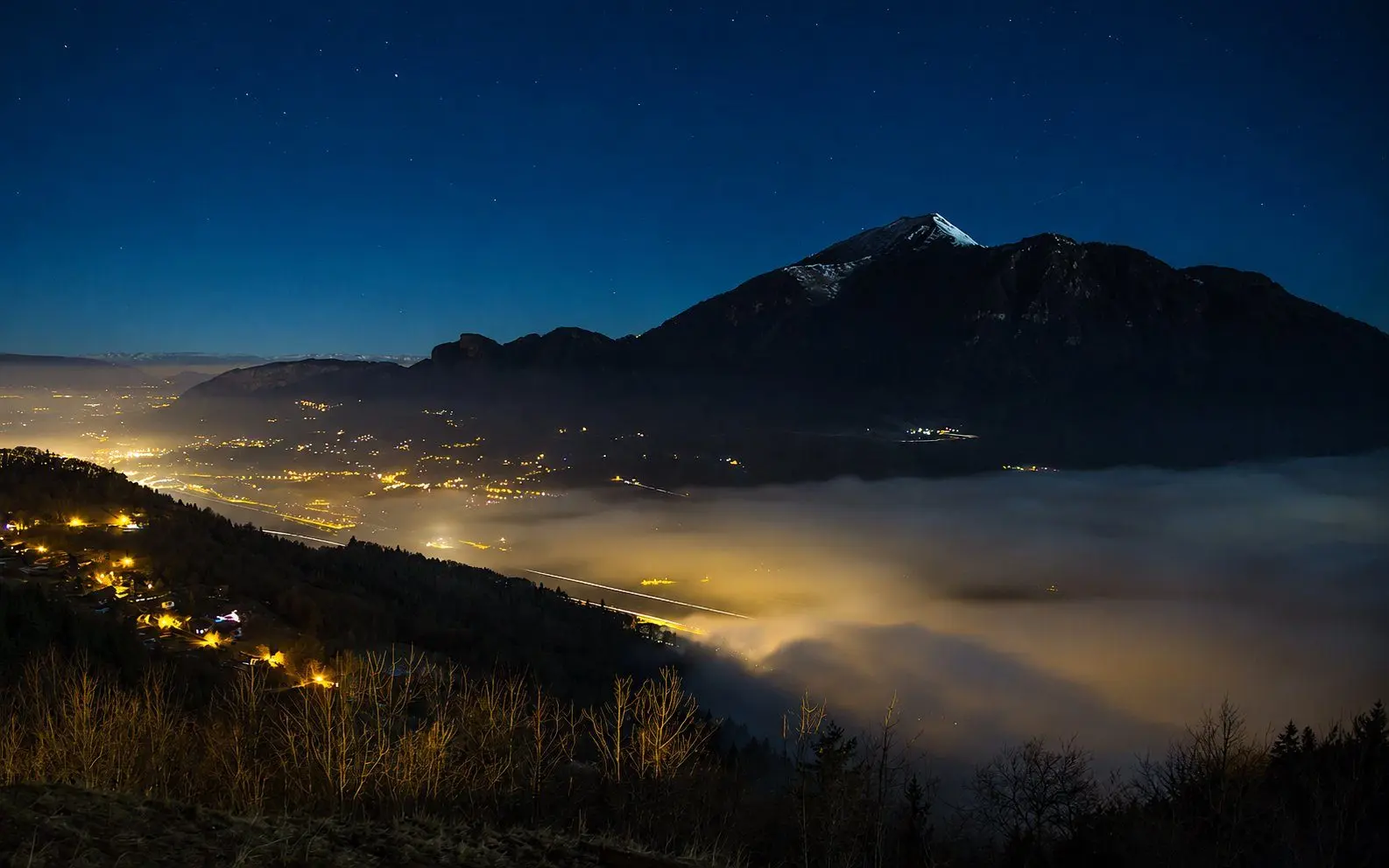 Vue nocturne depuis le belvédère de Mont-Saxonnex, mer de nuages dans la vallée de l'Arve et le Môle sous les étoiles