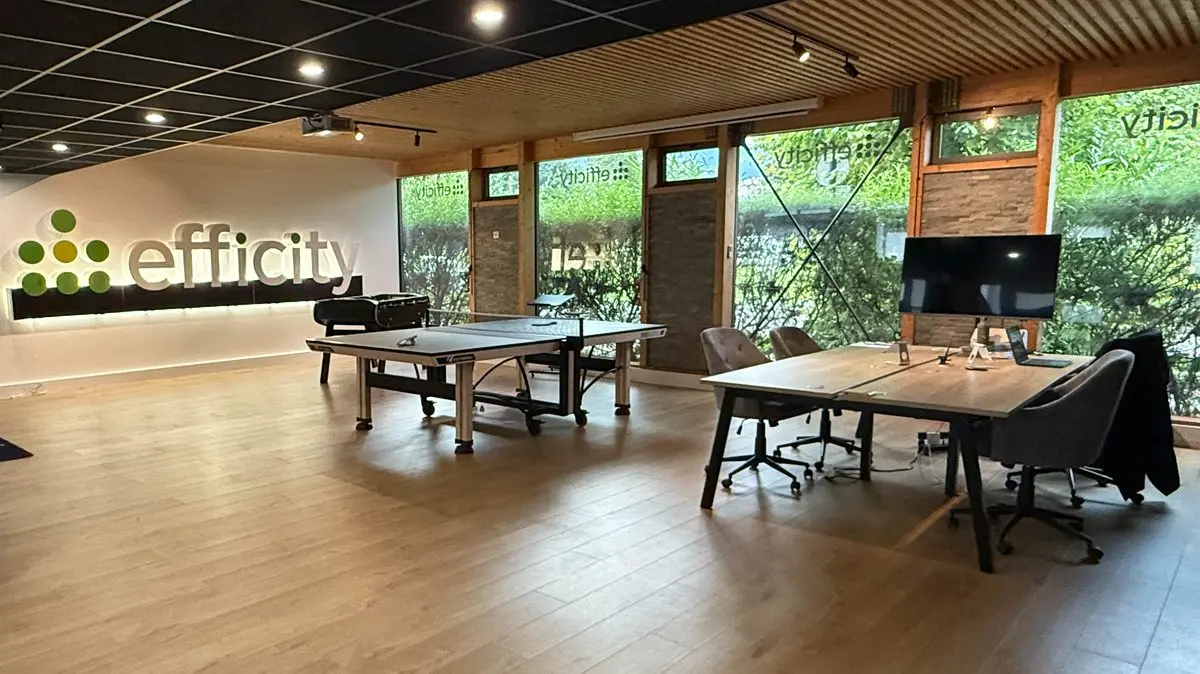 Espace de travail des bureaux Efficity Thyez avec logo et tables de coworking